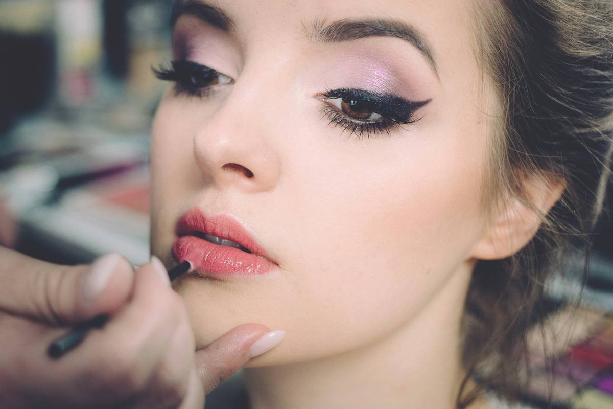 Actor applying long-lasting stage makeup with cream pigments under studio lights