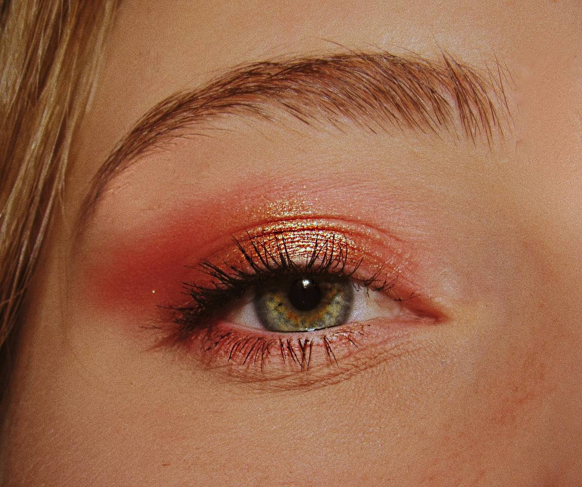 Actor applying comedic performance makeup with precision brushes near eyes and jawline