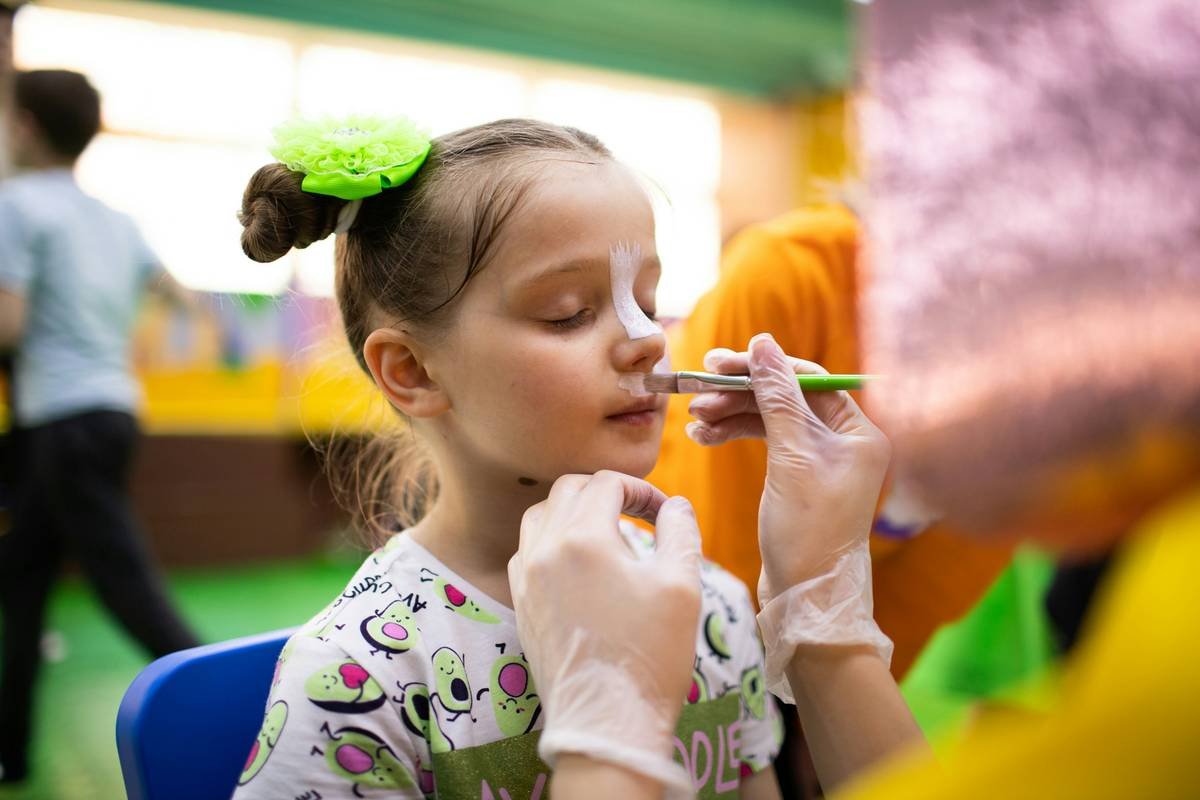 theatrical makeup for kids applied on a child's face as a friendly lion character